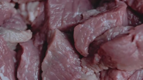 Butcher Cuts a Large Piece of Selected Meat on a Steel Table
