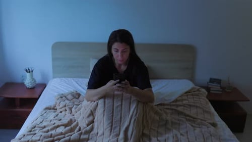 Night Insomnia Woman Using Smartphone in Bed in Dark Room