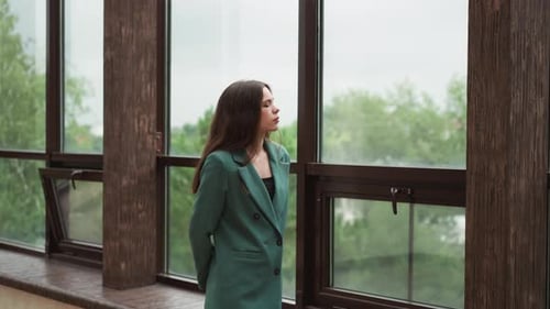 Woman Looking out Window in Modern Office