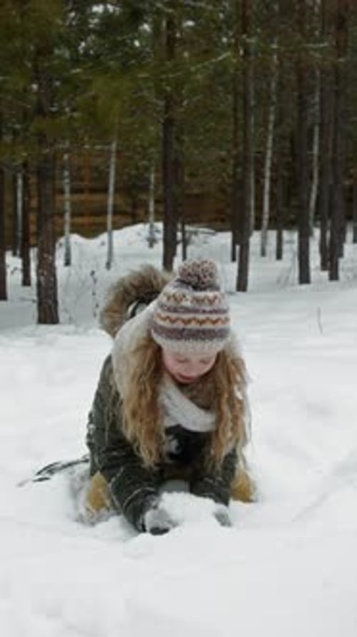 Girl in Snowy Woods Throws Snow in Air