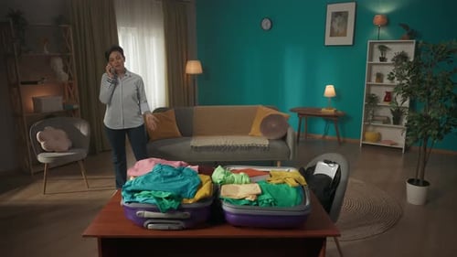 Woman Packs Suitcase and Talks on Phone