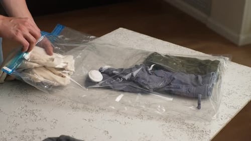 Packing Clothes Into Clear Storage Bag