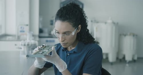 Technikerin analysiert Leiterplatte