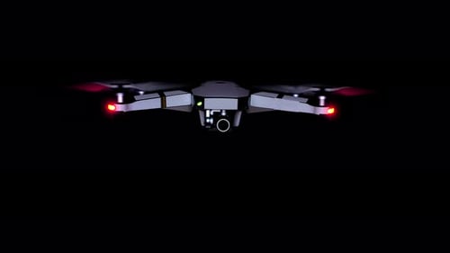 Close front view of drone with red lights, real time, isolated black background