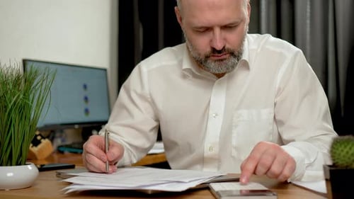 Mann benutzt Taschenrechner und Laptop für Mathe, Finanzen auf dem Schreibtisch, Steuerberichterstattung, Buchhaltung
