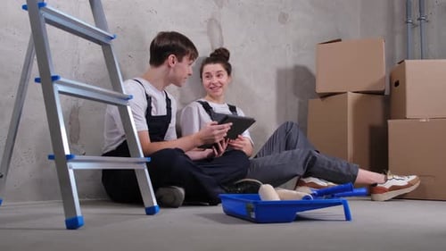 Couple in New Home During Repair Works Discussing About Home Design Project Looking Repair Plan on