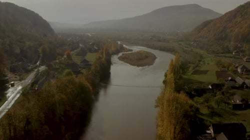 Flight Over the River in the Mountains in Autumn