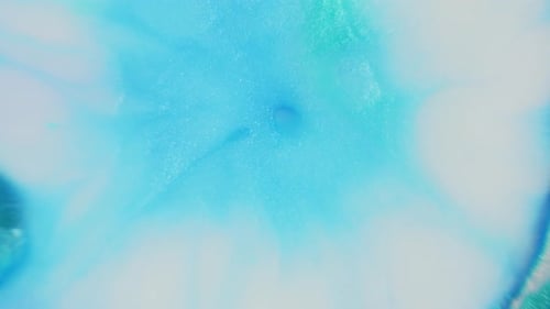 Soft turquoise ink cloud diffusing in water creating an ethereal abstract effect, ideal for backgrou