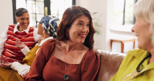 Women Laughing and Talking Together on Sofa