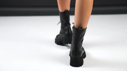 Female bare legs walk in modern stylish low boots.