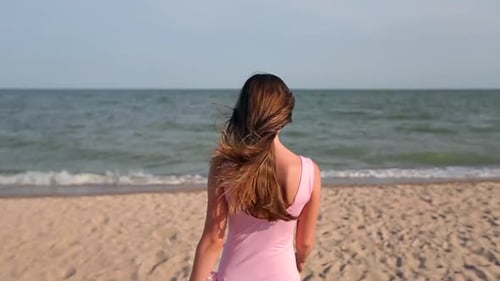 Back View of Woman Walking on Beach to the Sea Water Turns and Invites to Follow Her on Vacation