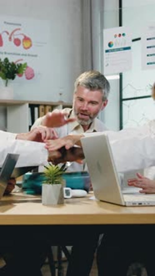 Doctors Discussing and High Fiving in Hospital Office