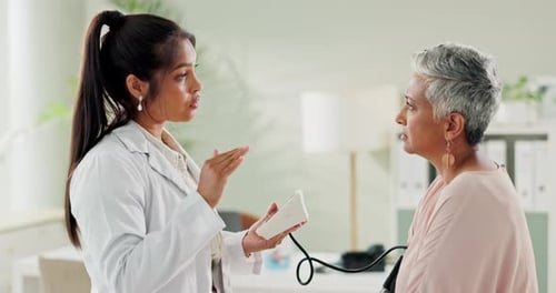 Clinic, doctor and check up with woman, blood pressure and healthcare, service and consultation