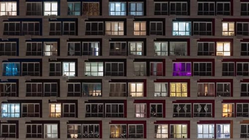 View of living apartment building windows at night.