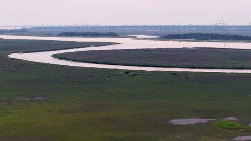 Aerial view of winding river through grassy marshland