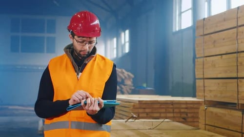 The Ingineer Works in a Warehouse Uses a Tablet