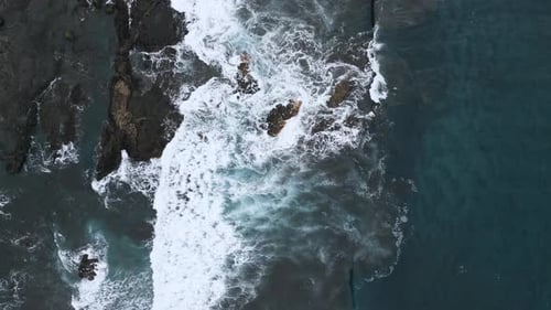 Vue aérienne des vagues de l'océan qui se brisent dans les rochers. Prise de vue statique