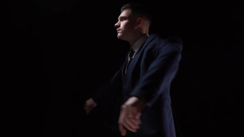 Man Adjusting Tie in Dramatic Lighting