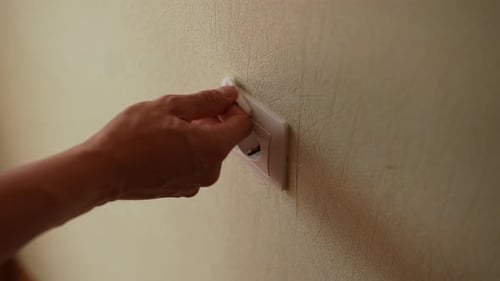 Closeup Hand of Unrecognizable Man Using Antibacterial Wipe to Clean Electrical Outlet on Wall for