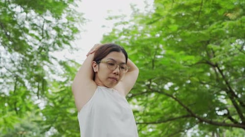 Woman Stretching Her Arms in a Green Park