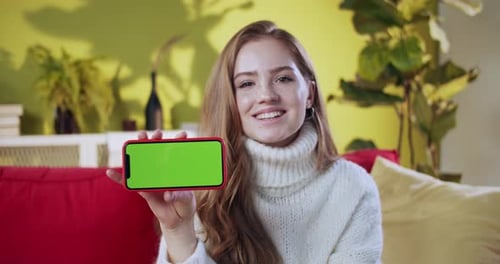 Woman Holds Phone With Green Screen Display