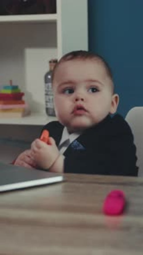 Child Explores Office Surroundings Carefully Curious Toddler Inspects Desk Items Near Electronic