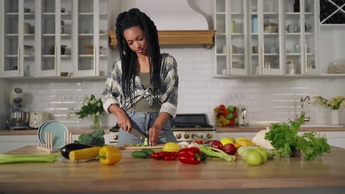 Woman Cutting Vegetables in Bright Kitchen
