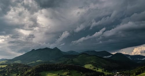 Dramatic Storm Clouds Over Mountains in Spring Landscape, Aerial Time Lapse