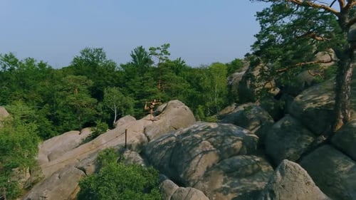 Woman Does Yoga on Rocky Hilltop