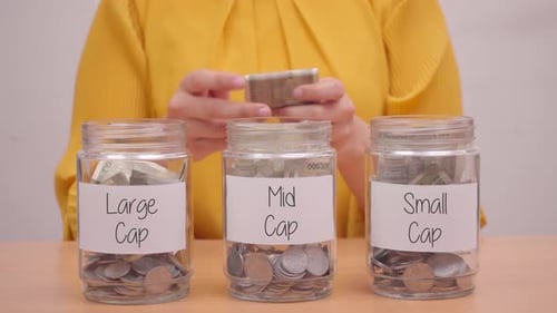Person Organizing Finances Into Investment Jars