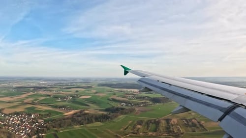 Luftaufnahme mit grünem Ackerland, kompakten ländlichen Siedlungen und wolkenlosem Horizont