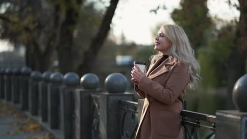 Woman Enjoys Coffee in Park
