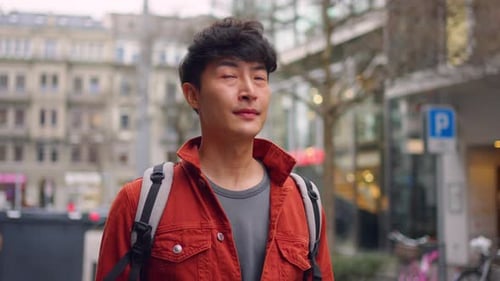 Asian attractive man backpacker walking around beautiful road in city.