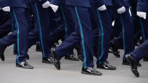 Uniformed Service Members Marching in Precise Formation During a Ceremonial Parade with Synchronized