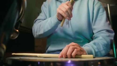 Drummer Playing Drums in Darkly Lit Studio
