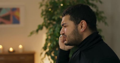 Man Talking on Phone Near Christmas Tree