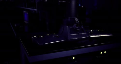 Dark Laboratory Setting with Illuminated Control Panel and Machinery