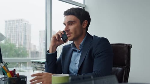 Professional Man Talking on Cellphone in Office