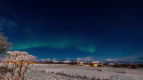 time lapse of bright northern lights over village in norway during winter night
