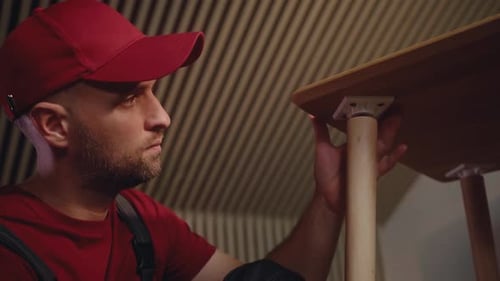 Man Assembling Wooden Table Leg Close Up