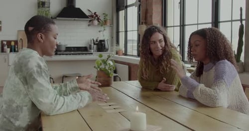 Females Friends Reading Tarot card on Kitchen table with Fortune Teller