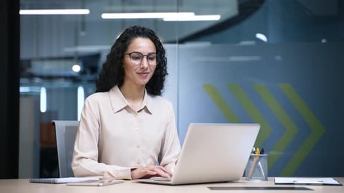 Portrait of a smiling businesswoman sitting at desk at a workplace in office. Confident happy