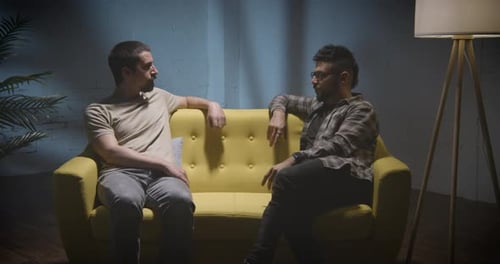 Two Men Sitting on Couch Having a Conversation
