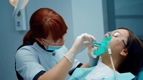 Dental specialist treats woman's teeth in clinic.