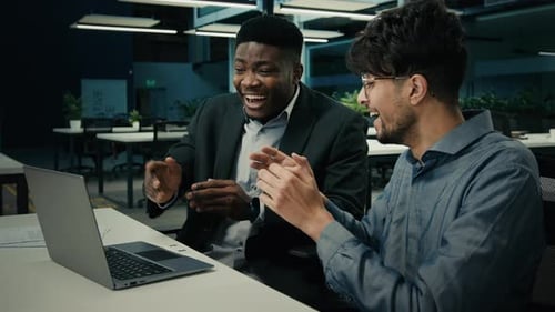 Two Young Adults Excited About Computer at Work