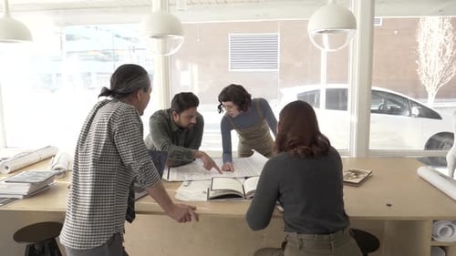 Colleagues Discussing Documents in Creative Studio Adult