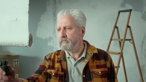 Adult Paints Indoor Wall with Paint Roller