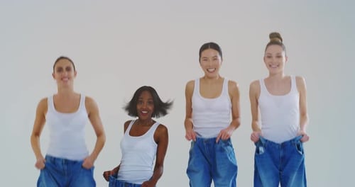 Four Women in Oversized Jeans Laugh in Studio