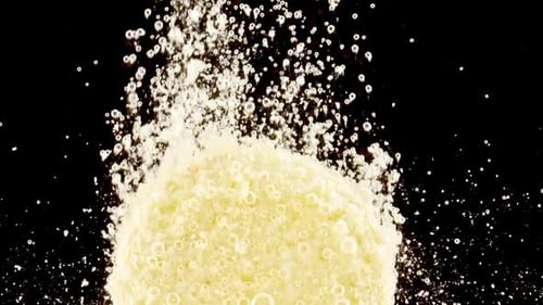 Close Up Tablet of Aspirin Vitamin C Falls Into of Water in Slow Motion on Black Background Macro