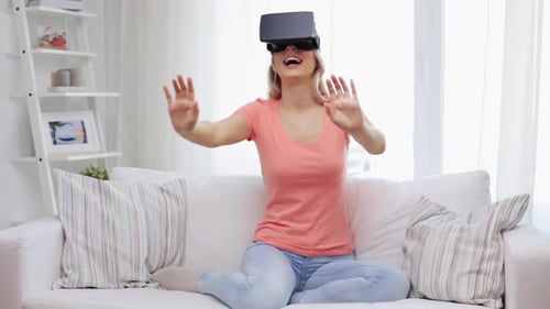 Excited Woman Using Virtual Reality Headset on Couch